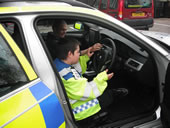 Student in driving seat of a police car